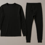 黒い長袖インナーと黒いタイツが並べて置かれた、シンプルなベースレイヤー上下セットの写真。無地でミニマルなデザインの肌着がフラットに配置されている。